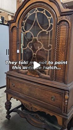 an old fashioned wooden cabinet with glass doors