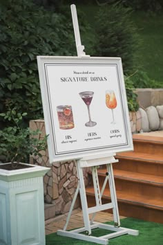 a sign that is sitting in front of some steps with drinks on top of it