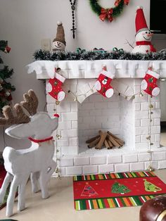 a fireplace decorated for christmas with stockings and reindeers hanging from it's mantle