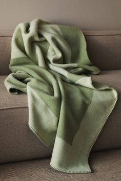 a green blanket sitting on top of a couch