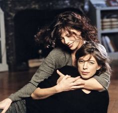 two women sitting on the floor hugging each other