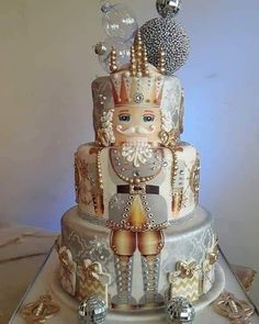 a three tiered cake with an elaborate design on it's side and decorations on the top