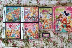 four nintendo wii games sitting on top of a flower covered bed next to each other