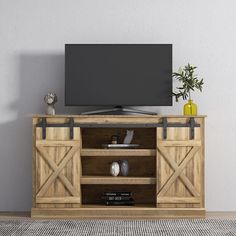 an entertainment center with sliding doors and a flat screen tv mounted on top of it