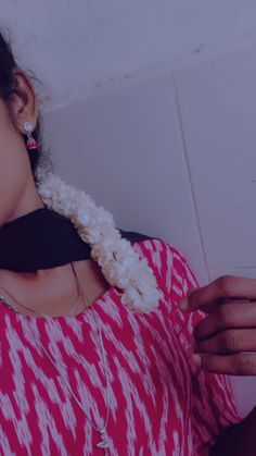 a woman in a red and white top is holding a cell phone up to her ear