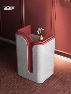 a small vase sitting on top of a trash can next to a red wall and floor