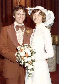 a man and woman dressed in wedding attire posing for a photo with the bride holding her bouquet