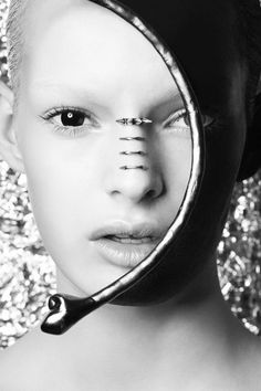 a woman is shown through a mirror with her nose ring in the shape of an arrow