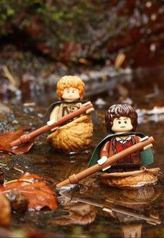 two lego figures are in the water with their oars