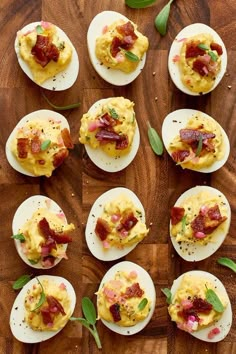 deviled eggs with bacon and spinach garnishes on a wooden cutting board