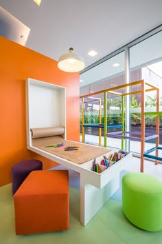 an orange and white room with two stools, a table and a bench in it