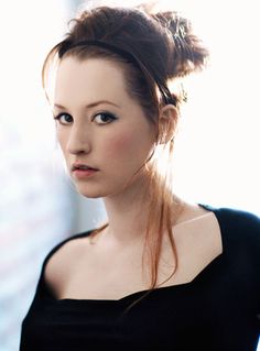 a woman with red hair wearing a black dress