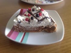 a piece of cake on a plate with whipped cream and cherries in the middle