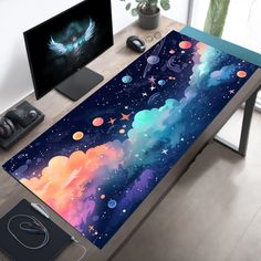 a computer desk with a painting on it