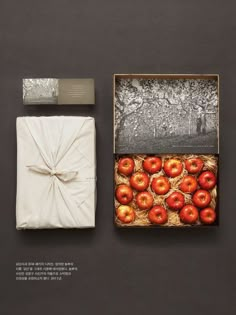 an open box with apples in it next to a white napkin and silver foil wrapper