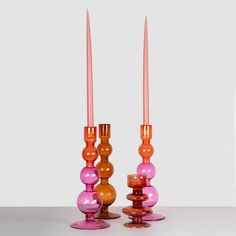 two orange and pink candlesticks sitting next to each other