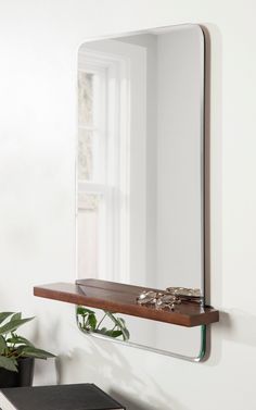 a mirror hanging on the wall above a shelf