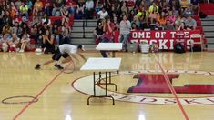 two people are performing tricks on a basketball court while an audience watches from the sidelines