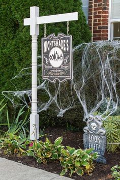 a halloween yard decoration with spider webs and a sign that says nightshade's