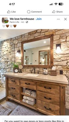 an image of a bathroom with stone walls and wood furniture on the counter top, along with a large mirror above it