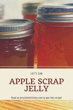 two jars filled with apple scrap jelly sitting on top of a wooden table