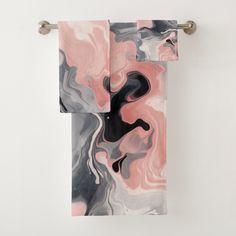 two towels hanging on a towel rack with marbled paper and metal handles in front of white wall