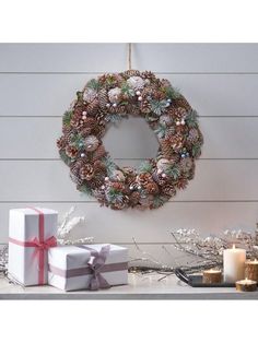 a wreath with pine cones and christmas decorations