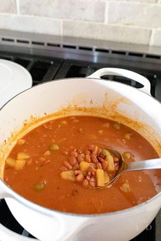 a pot filled with soup sitting on top of a stove next to a white oven