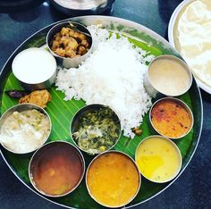 a plate full of different types of food on a table with rice and sauces