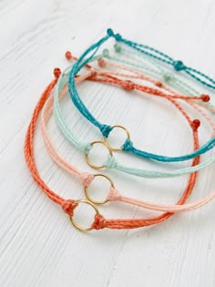 These fun bracelets are waterproof and great for anyone who is often doing outdoor activities. They would make a nice gift. Stack these together, with other bracelets, or wear them by themselves! They are perfect for everyday wear! ∙ ∙ ∙ ∙ ∙ ∙ ∙ ∙ ∙ ∙ ∙ ∙ ✦ MATERIALS ✦ * High-Quality Waxed Polyester Cord * Open Circle Charms ∙ ∙ ∙ ∙ ∙ ∙ ∙ ∙ ∙ ∙ ∙ ∙ ✦ SIZES ✦ These bracelets are adjustable from about 5.5 Inches to 8.5 Inches. They are made to order so if you need a custom size please let me know. I'm happy to do that for you.  ∙ ∙ ∙ ∙ ∙ ∙ ∙ ∙ ∙ ∙ ∙ ∙ ✦ PLEASE NOTE ✦ When you first receive this bracelet, it may feel slightly waxy, which may make it more difficult to adjust. The waxy texture does not last. After a day or two of wearing, the waxy texture will fade, and it will be much easier t How To Make Wax Cord Bracelets, Waxed Cord Bracelets, Wax Bracelet Ideas, Wax Cord Bracelet Diy, Wax String Bracelet Ideas, Wax Bracelets, Summer Adjustable Bracelet, Cheap Waxed Cord Bracelets For Beach, Puravida Bracelets