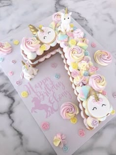 a unicorn themed birthday cake on top of a table