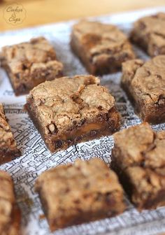 some brownies are sitting on top of a piece of paper and have been cut into squares