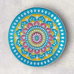 a blue and yellow plate sitting on top of a white table next to a wall