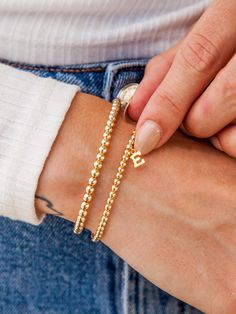 Make your stack personal with an Initial Charm! Wear your own initial, your children's, or a loved one's for a sentimental touch — or gift the heartwarming piece to someone you love. Designed with durability in mind, our gold-fill beads and charms are secured on extra-strength stretch cord to withstand your busy life and maintain their shine. Whether you dress them up, dress them down, or pile them on, you’ll truly never take them off. Everyday Stretches, Pyrite Bracelet, Letter Bracelet, Initial Bracelet, Initial Jewelry, Dainty Bracelets, Childrens Jewelry, Name Bracelet, Layered Bracelets