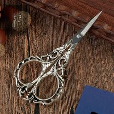 a pair of scissors sitting on top of a wooden table next to a bottle opener