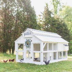 a white chicken coop with chickens in it