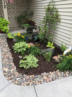 a front yard garden with rocks and plants