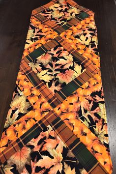 an orange and black table runner with leaves on it