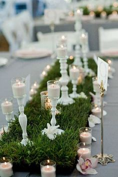 a table topped with lots of white candles