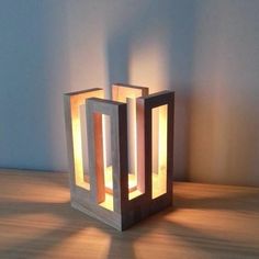 a light that is sitting on top of a wooden table in front of a wall