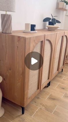 a large wooden cabinet sitting on top of a hard wood floor next to a lamp