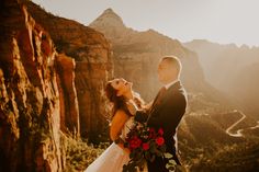 a bride and groom standing on top of a mountain