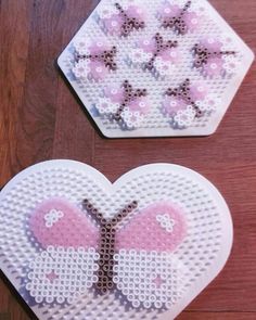 two heart shaped coasters sitting on top of a wooden table