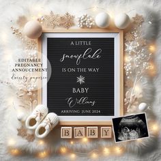 a baby announcement with snowflakes, shoes and other items on the floor next to it