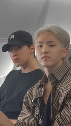 two young men sitting next to each other on an airplane