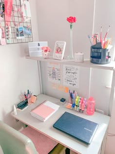 a desk with several pens, notebooks and other office supplies on top of it