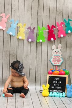 a baby sitting on the floor in front of some bunny bunnies and other decorations