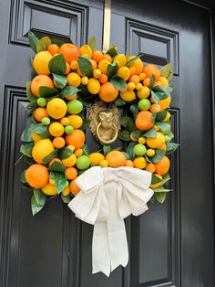 a wreath with oranges and lemons hanging on a door