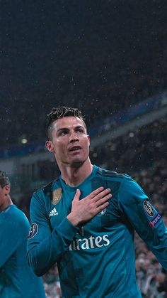 the soccer player is holding his hands together as he stands in front of an audience