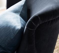 the back end of a black couch with blue velvet upholstered on it's arm